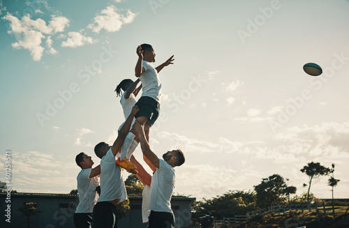 Rugby, team jump and lift for ball and teamwork, sport and training for game, fitness and exercise or sports performance with blue sky. Group, men and lifting man to catch and professional match