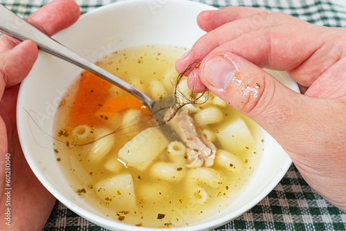 Man found hair in his bowl of soup and isn't satisfied with the food. Situation causing nausea. Failure to follow hygienic cooking practices, bad customer service, no chef's hat.