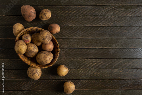 Top view of harvest potatoes roots on wooden background