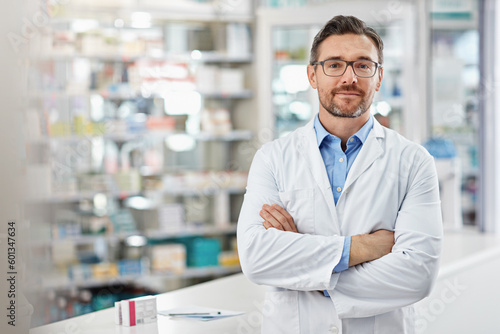 Healthcare, crossed arms and portrait of a male pharmacist standing in a pharmacy clinic. Pharmaceutical, medical and mature man chemist with confidence by the counter of medication store dispensary.