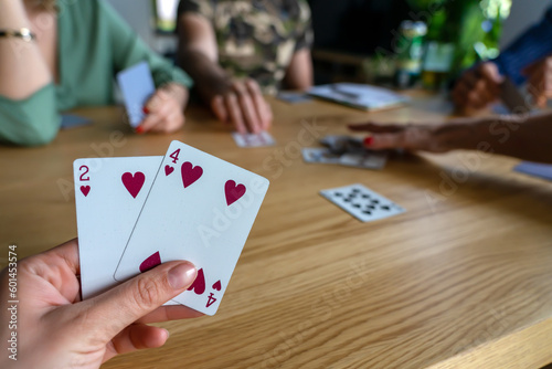 Woman playing with cards with friends close up