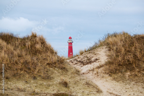 View between two dunes on the red lighthouse of the Dutch island Schiermonnnikoog 