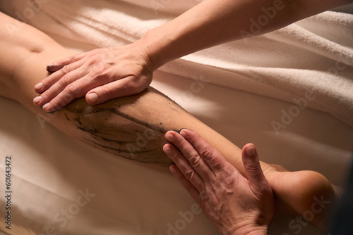 Experienced massotherapist giving anti-cellulite massage to female client