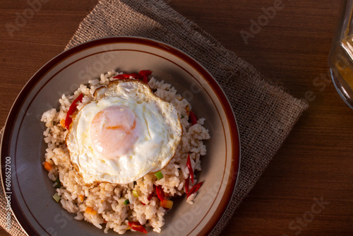 Fried rice with fried egg on top. indo-china food with green onion, carrot and red chili
