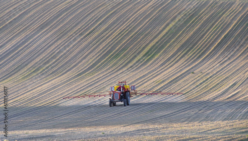 Stary traktor pracujący w polu. Opryskiwanie upraw wiosną na Lubelszczyźnie w Europie.