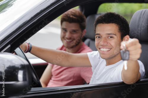portrait of young men in car holding keys