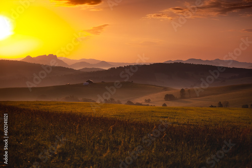 Kacwin i okolice - Bacówka i krajobraz Spiszu. Piękny zachód słońce ponad zamglonymi górami i polami. 