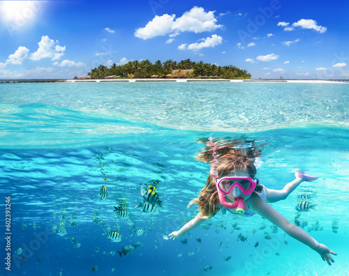 Split image with a tropical island and underwater life with a girl snorkeling in the ocean of the Maldives with colorful fish