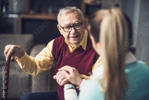 Home doctor is visiting senior man to check his health. Professional caregiver is assisting old man at his home.