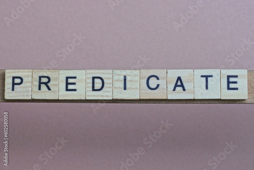 gray word predicate made of wooden square letters on brown background