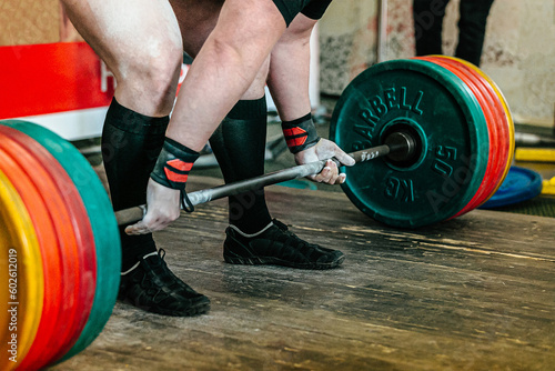 athlete powerlifter performing deadlift heavy barbell at powerlifting competition, power sports games