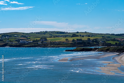 View of the famous Irish beach of Inchydoney on a sunny summer day. The beautiful Atlantic coast of Ireland. Summer seaside resort, landscape, body of water aerial view. Clear blue sky, sea coast
