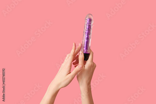 Woman with vibrator from sex shop on pink background