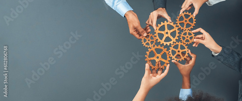 Panoramic shot top view of business people holding cog wheel as unity and teamwork in corporate workplace concept. Office worker colleague with symbol of visionary system for business success. Concord