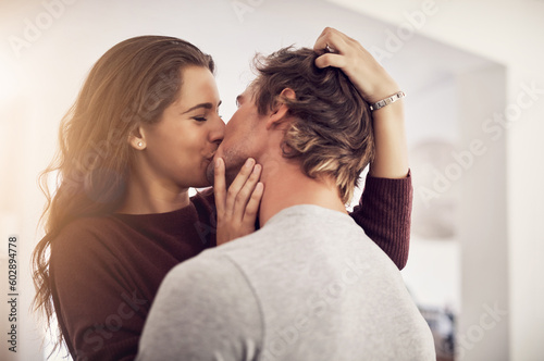 Face of happy woman, man and kiss with love in apartment for romance, intimacy and special moment together. Young couple kissing in home for romantic relationship, happiness and passionate partner