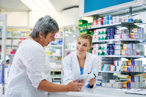 Pharmacist explaining medicine to a woman in the pharmacy for pharmaceutical healthcare prescription. Medical, counter and female chemist talking to a patient about medication in a clinic dispensary