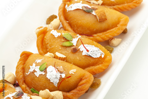 Close-up of Indian Traditional sweet "Gujiya", The sweet is made of maida (flour), and ghee, filled with Dry fruits. Front view, isolated on white.