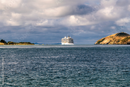 Cruise ship sails out of the bay to the ocean