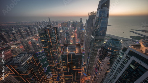 Skyline sunset view of Dubai Marina showing canal surrounded by skyscrapers along shoreline day to night timelapse. DUBAI, UAE