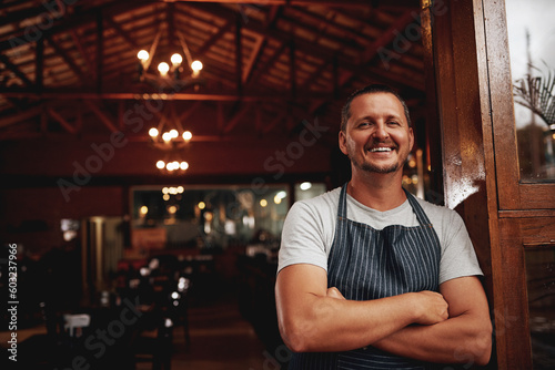 Happy man, portrait and small business owner of restaurant, cafe or pub with a smile for career pride. Male entrepreneur person as manager, barista and waiter at door for shop welcome greeting