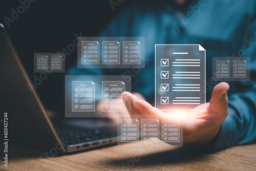 Document control and management concept, Businessman review procedures through the use of laptops and show digital checklist documents in hand technology on digital document paperless operation