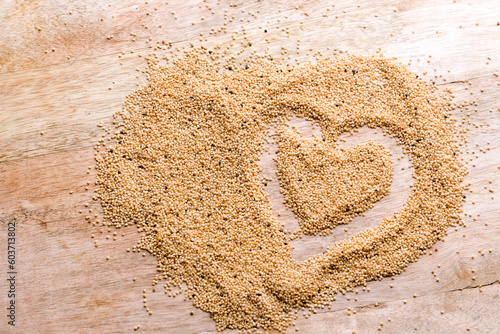 Amaranth seed abstract background. Heart on wooden table with seeds