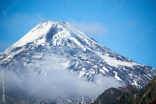 View of the Villarrica volcano during the autumn season with snow on its summit.