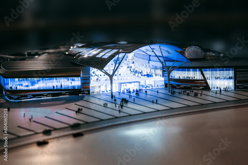 Model of modern shopping complex - hypermarket and silhouettes of people in front of the entrance