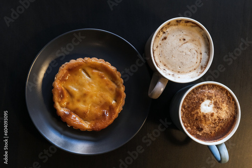 Pastel de nata and two cup of cappuccino, top view