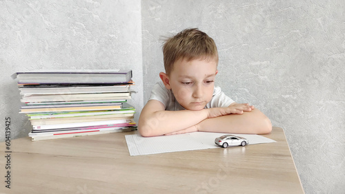 Tired boy with ADHD is bored in class, distracted, does not want to do homework. Therapy for ADHD children. Attention deficit and hyperactivity in children, neuropsycho