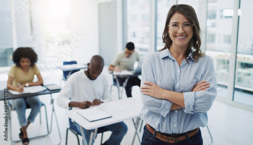 Education, portrait and woman professor in a classroom with students for teaching, knowledge and motivation. College, teacher and face of female leader happy in a class with group of people learning