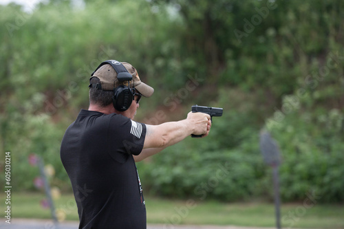 Man shooting with a gun at the outdoor range