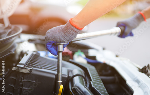 Car mechanic using the torque wrench to repairing in car engine room. a mechanics repair service garage. working on a car service. Car Maintenance and Repair concept.