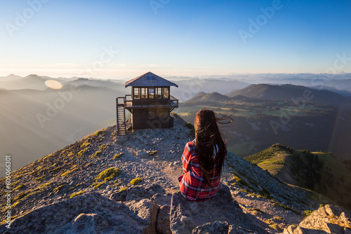 Girl sitting on the top of Mount Fremont with Mount Fremont fire lookout on the background in Mount Rainier National Park
