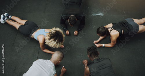 Top view, fitness and people do push up in circle in gym for training, exercise and workout class. Teamwork, body builder and men and women in sports club for challenge, wellness or strength on floor