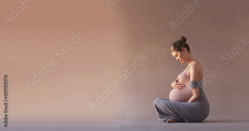 Young healthy pregnant woman doing yoga exercises and meditating at home. Health care, mindfulness, relaxation and wellness concept. 