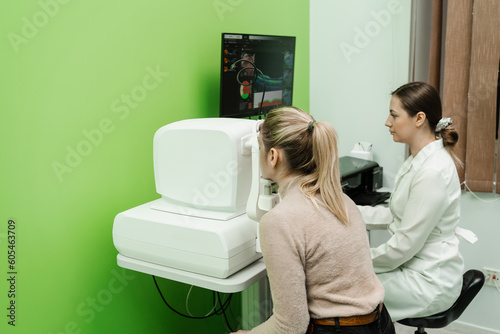 Optical coherence tomography OCT scan to create pictures of the back of eye. Examination of eyes of patient using optical coherence tomograph. Ophthalmologist is scanning cornea of woman patient.