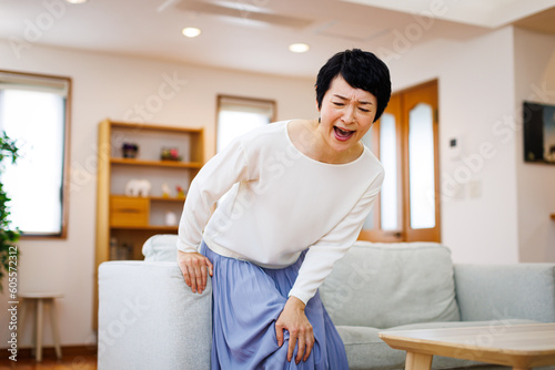 家で膝の痛みに苦しんでいる成熟した日本人女性