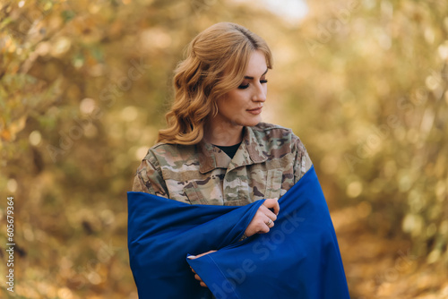 A Ukrainian military woman with a Ukrainian flag.