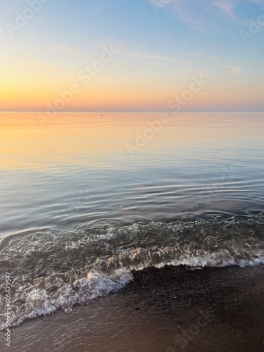 Tender colors of the evening sky, reflection on the sea surface, tender seascape background, blue and purple sky reflection on the water