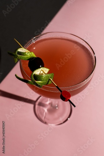 Vertical shot of a cosmopolitan cocktail with a pastel background