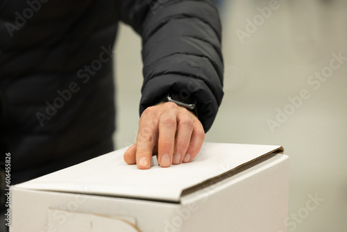 Main avec bulletin de vote et boîte de vote, hand with vote box, horizontal