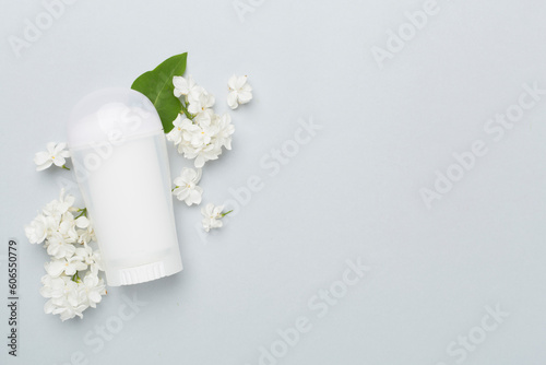 Composition with deodorant and flowers on color background, top view