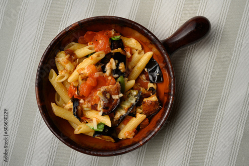 Pasta alla Norma or Penne Rigate with Eggplant and Tomato Sauce and Ricotta in a Rustic Terracotta Bowl