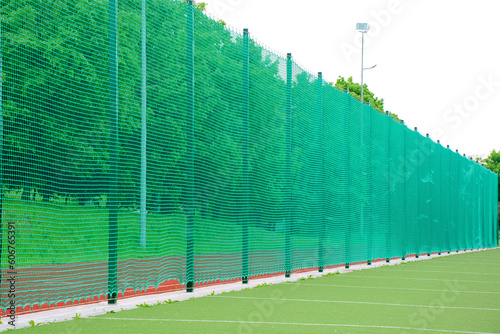 The fence is a combination of mesh and metal posts that separate the sports field