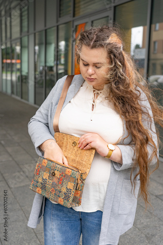 Young woman searching for phone in her handbag, one person, portrait