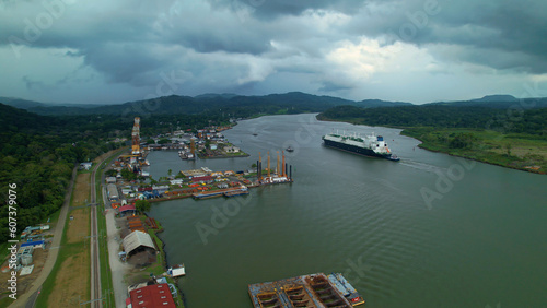 Dark rain clouds rolling over port and cargo ship passing through Panama Canal
