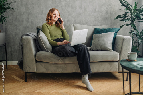 Happy young woman caller talking on the phone at home, cheerful teen girl enjoys pleasant mobile conversation, smiling millennial female holding cell speaking making call by telephone in living room. 