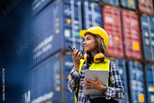 Female workers in the container industry transporting imports and exports of goods to the shipping business. Confident engineer in container terminal.