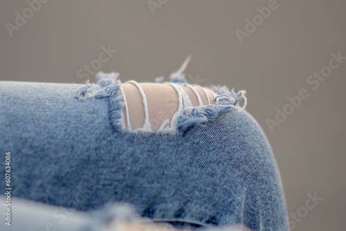 A hole in the denim pants. Close-up. Very soft focus